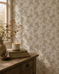 Taupe floral vine wallpaper in cozy room with candle and books.