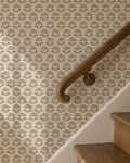 Taupe floral wallpaper with cream background on staircase wall, rustic style.