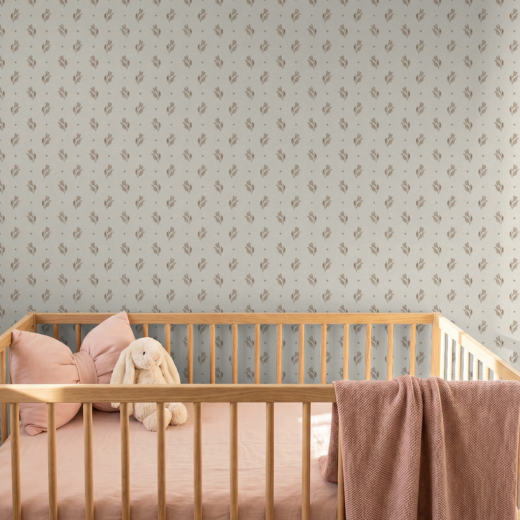 Taupe floral wallpaper in nursery with wooden crib and pink bedding.