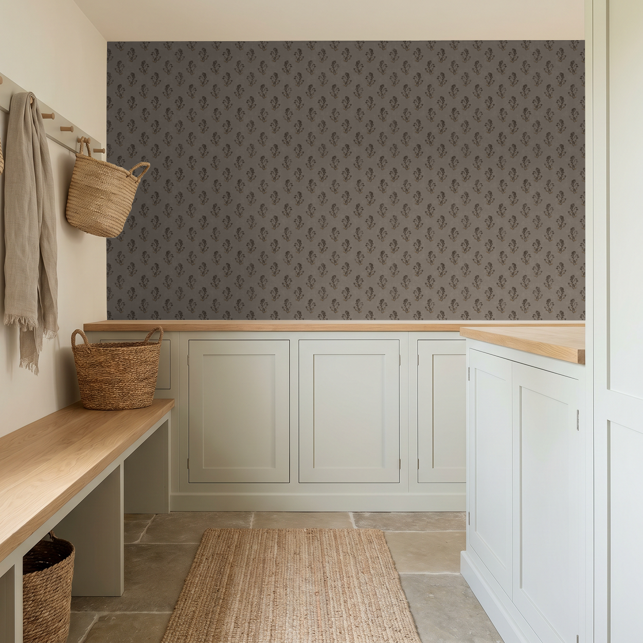 Taupe floral wallpaper in a rustic mudroom with wicker baskets and wooden bench.