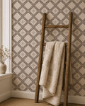 Taupe geometric floral wallpaper in cozy room with wooden ladder and beige throw.