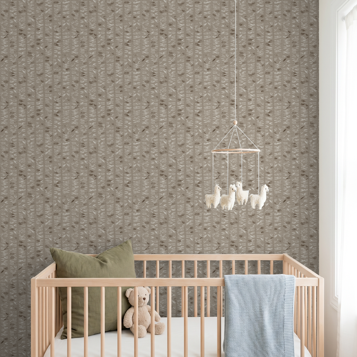 Taupe olive branch wallpaper in nursery with crib and mobile.