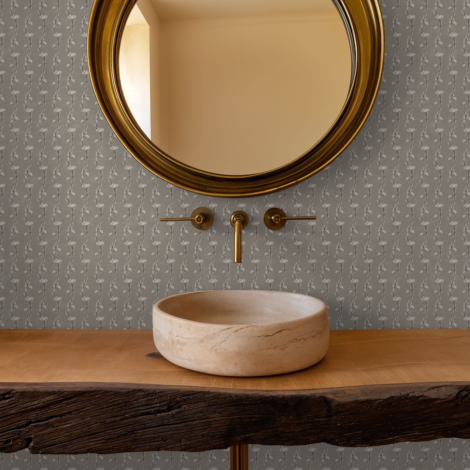Taupe vine wallpaper with round mirror and rustic sink in bathroom.