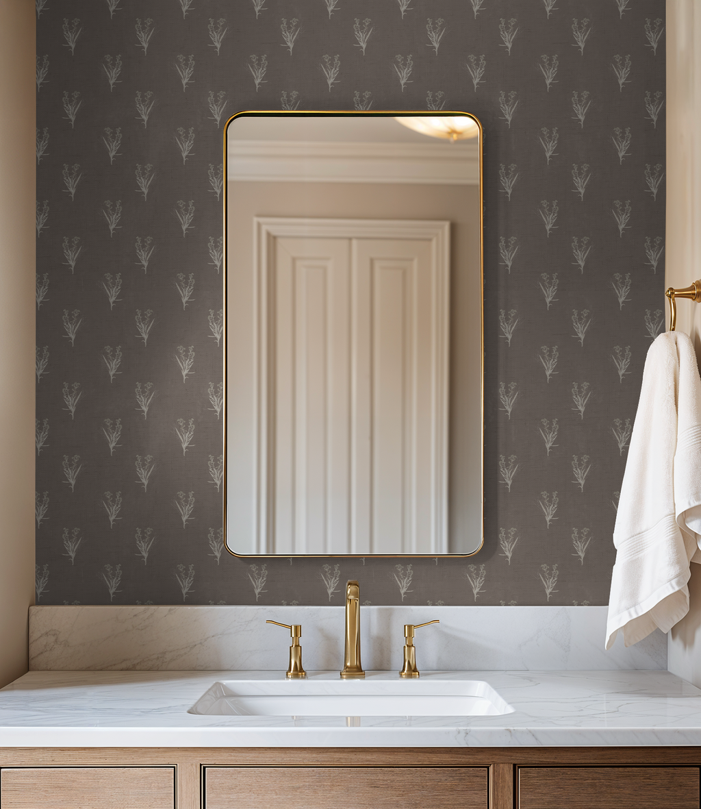Bathroom with taupe wildflower wallpaper, gold fixtures, and marble countertop.