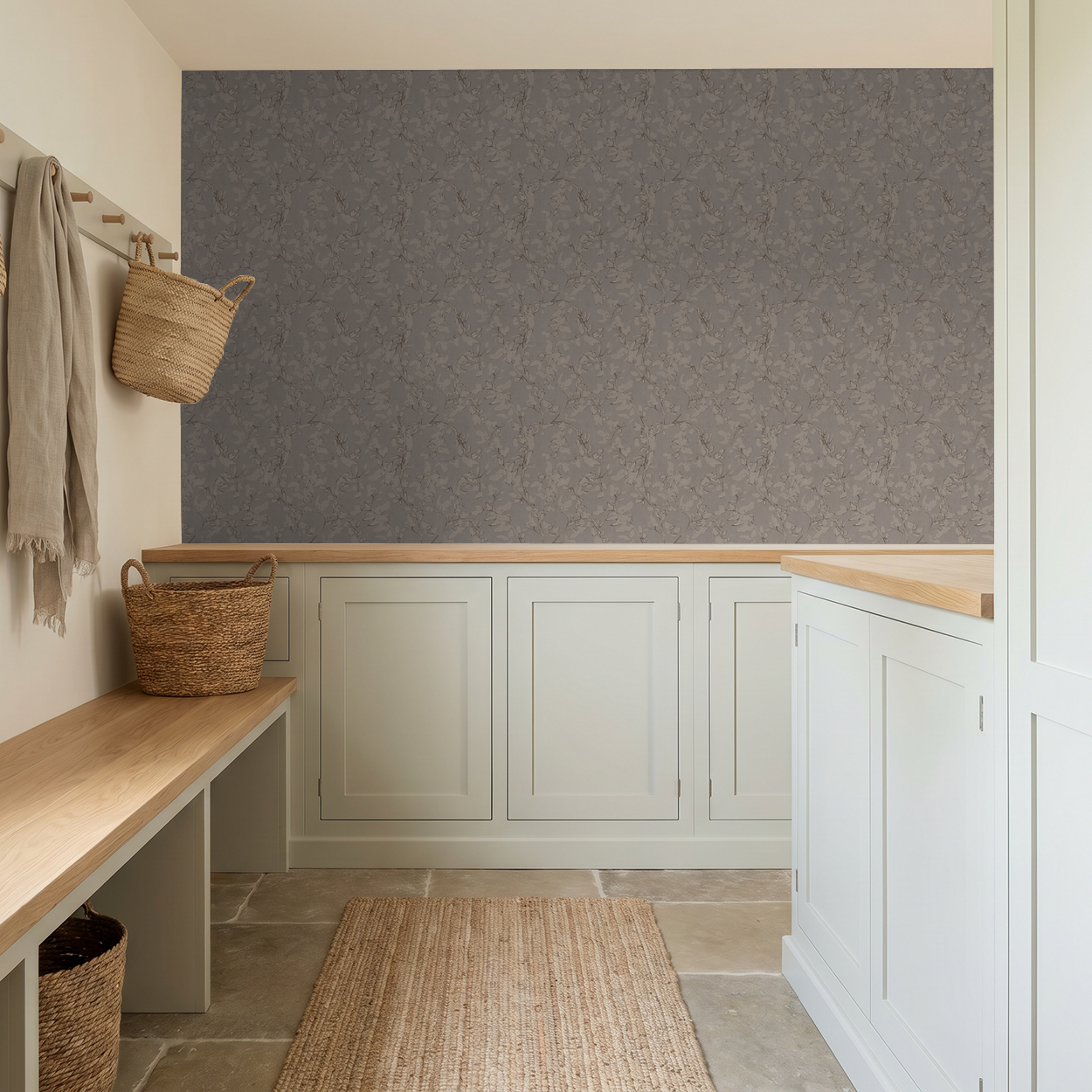 Trailing floral vine brown wallpaper in a rustic mudroom with white cabinets and woven baskets.