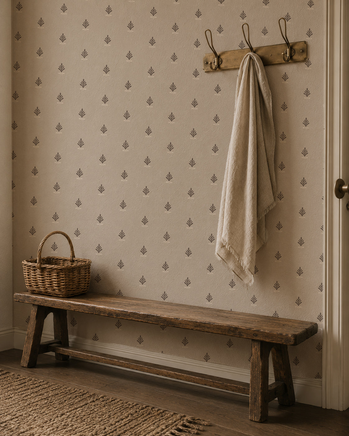 Vintage block print wallpaper with taupe floral motifs in rustic entryway with bench and basket.