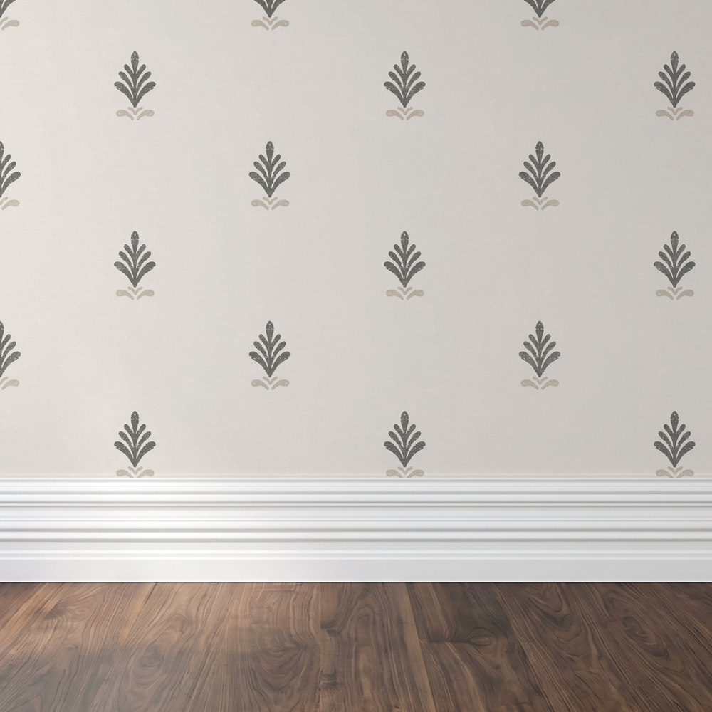 Vintage block print wallpaper with charcoal and taupe motifs on cream background in elegant room setting.